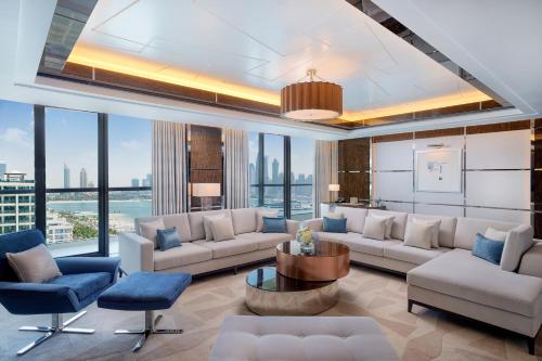 a living room with a couch and chairs and a table at Hilton Dubai Palm Jumeirah in Dubai