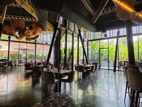 a dining room with tables and chairs and windows at The Golkonda Resort and Spa in Hyderabad