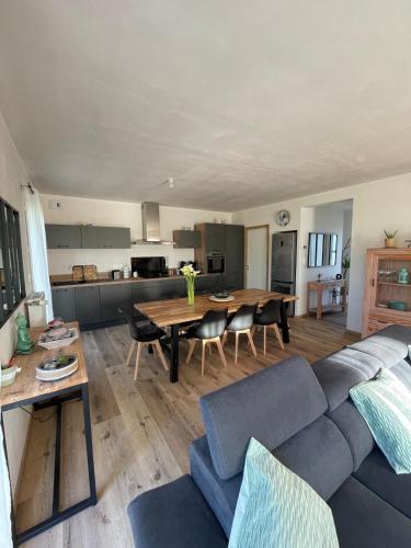 un salon avec un canapé bleu et une table dans l'établissement Le Gite d'Almaju 3 étoiles, 3 chambres, 6 couchages, à Plestin-les-Grèves