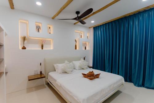 a bedroom with a large bed with blue curtains at Hoshi Villas in General Luna