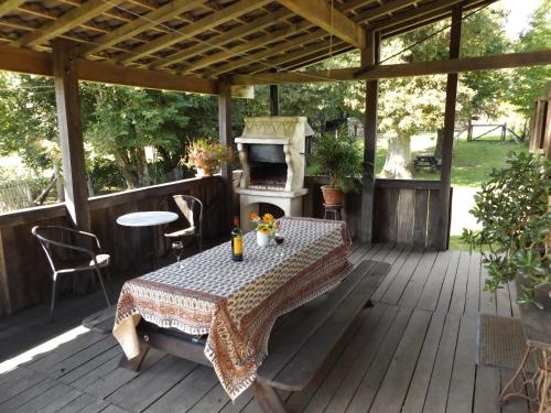 une terrasse en bois avec une table et une cuisinière dans l'établissement Cottage in Dordogne, à Château-Chervix