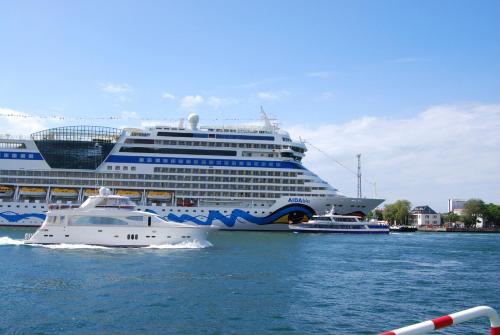 een cruiseschip en een kleine boot in het water bij Ferienwohnung Heidelbeere in Graal-Müritz