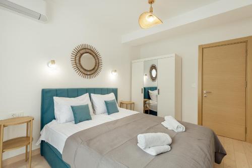 a bedroom with a large bed with two towels on it at Hi Montenegro - RiverSide Apartment in Igalo