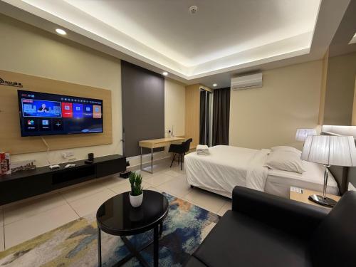 a hotel room with a bed and a tv at QUINCE HOME GRAND ION DELEMEN GENTING HIGHLANDs in Genting Highlands