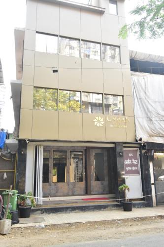 a tall building with windows and plants in front of it at Urban Nest in Mumbai