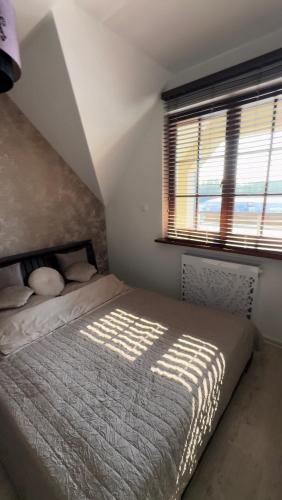 a bedroom with a bed and a window at Harbor Apartment in Ustka