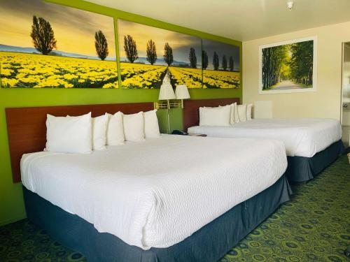 two beds in a hotel room with flowers on the walls at Days Inn by Wyndham Westley in Westley