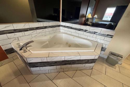 a white bath tub in a bathroom with a sink at Super 8 by Wyndham Pontoon Beach IL/St. Louis MO Area in Pontoon Beach