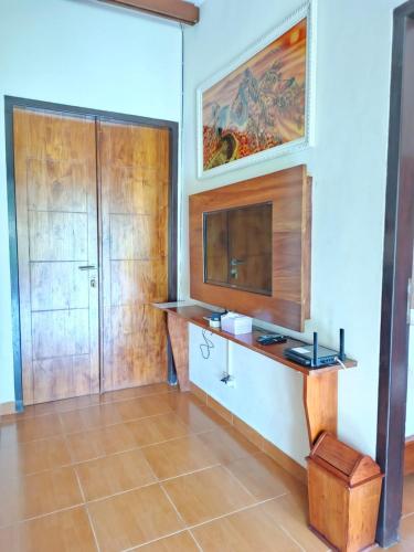 a living room with a tv and a wooden cabinet at Spring Hill Hotel Ruteng in Ruteng