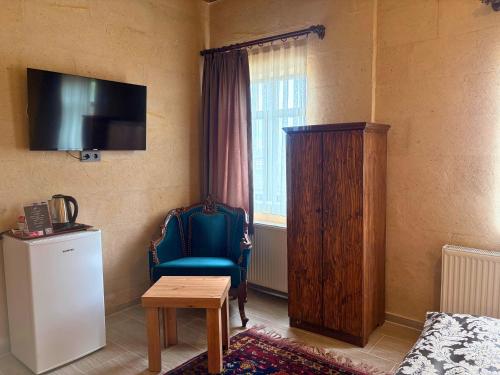 a room with a chair and a television on the wall at Elysee Cave House in Goreme