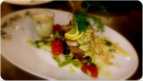 a white plate of food with vegetables on a table at Hotel Gasthof Tirolerwirt in Bischofshofen