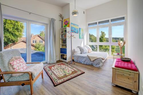 a living room with a bed and a large window at Ferienhaus Ostroher Moor in Ostrohe