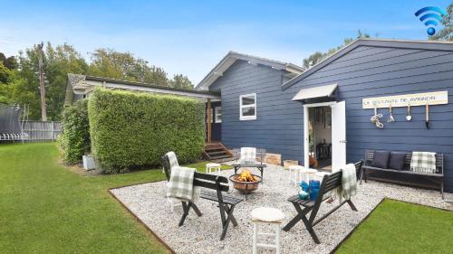 a backyard with a table and chairs and a house at Amber Cottage in Bowral