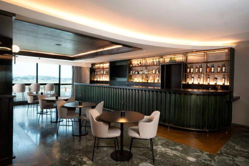 a restaurant with tables and chairs and a bar at Hilton Mexico City Airport in Mexico City