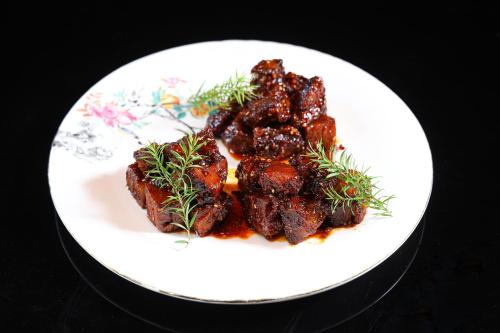 a plate of food with meat on a table at Honglu Garden Hotel Bell and Drum Tower Huimin Street Store & 2 bottles of beer for free in Xi'an