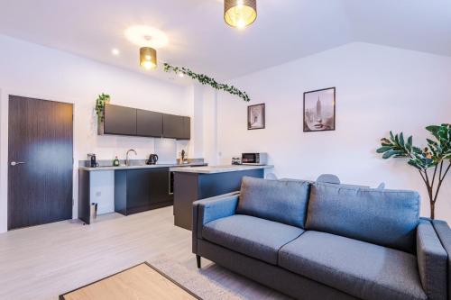 Una sala de estar con un sofá y una cocina. en Cohost Partners Chic Stay Heart of Warrington, en Warrington