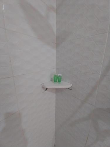 two green candles sitting on a shelf on a wall at Sujiwa Ubud Hotel & Villa in Ubud