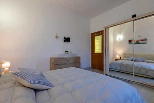 a bedroom with a large bed with a large mirror at Villetta I Pitosfori in Palmadula