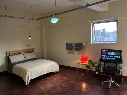 a bedroom with a bed and a flat screen tv at I Know a Spot! In Johannesburg in Johannesburg