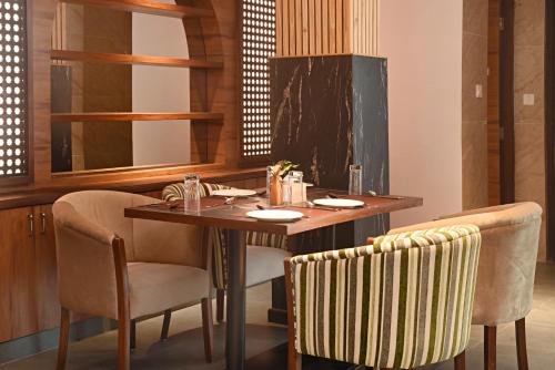 a dining room with a wooden table and chairs at Temple Suites Kathmandu in Kathmandu