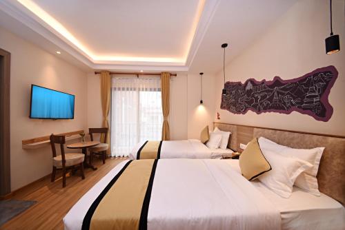 a hotel room with two beds and a tv at Temple Suites Kathmandu in Kathmandu
