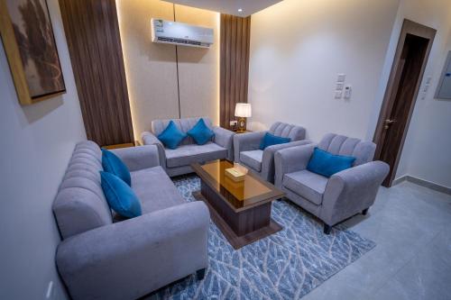 a living room with couches and blue pillows at بروليت للشقق الفندقية in Khamis Mushayt
