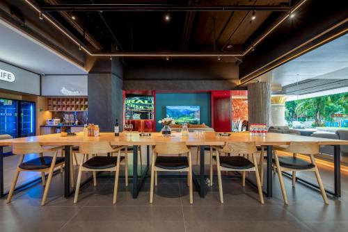 a dining room with wooden tables and chairs at 西双版纳景洪恩季国际酒店 in Jinghong