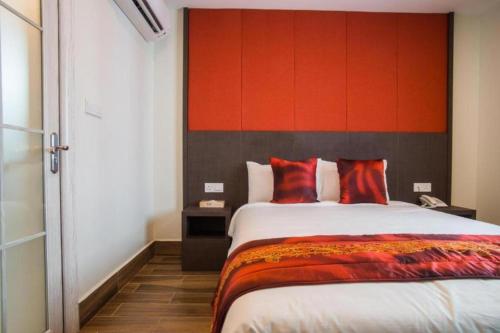 a bedroom with a large bed with a red headboard at D'Spark Hotel Bayu in Klang