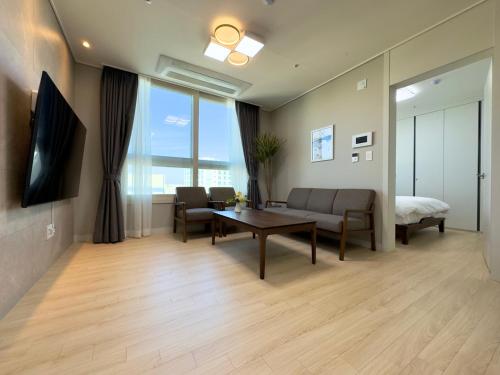 a living room with a couch and a table at Eunhasu D&M Residence in Daejeon