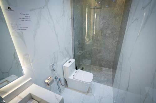 a white bathroom with a shower and a toilet at بروليت للشقق الفندقية in Khamis Mushayt