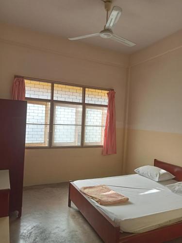 um quarto com uma cama e duas janelas em Suksabai Hotel Phuket em Cidade Phuket