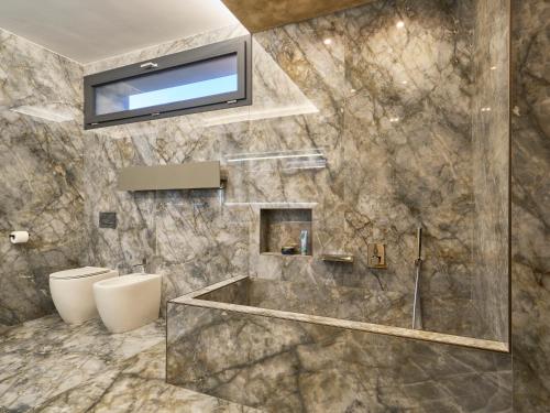 a bathroom with a tub and a toilet and a television at Monza Design Villa by GIOs Private Pool in Monza