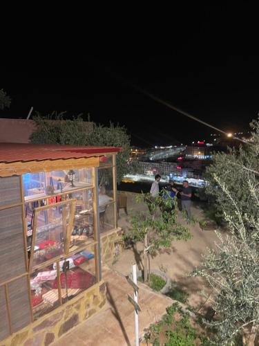 a night view of a building with people standing around at RoadHouse - Petra in Wadi Musa