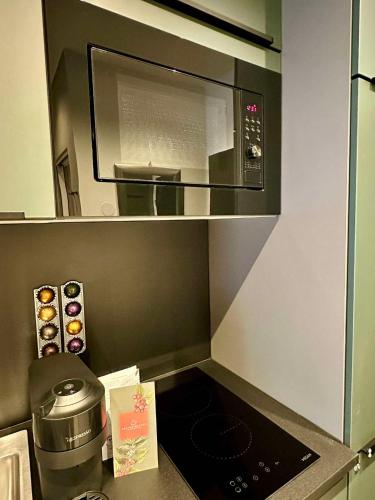 a kitchen with a microwave oven and a stove at Red Velvet-Romantik Appartement mit Balkon & Flussblick - Das Alpenzeit im Zentrum mit Parkplatz in Bad Aussee
