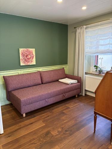 a couch in a living room with a window at das CHISTO - Ferienwohnungen im Herzen der Kneippstadt in Bad Wörishofen