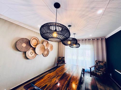a room with two chandeliers and logs on the wall at 34 Saligna st - 6 Guests Self Catering in Polokwane