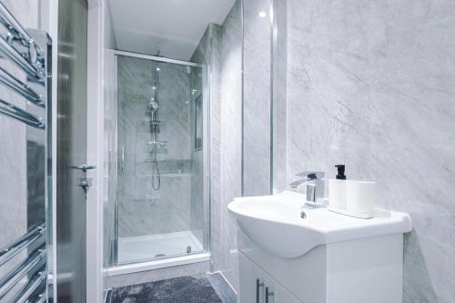 a white bathroom with a sink and a shower at Cohost Partners Central Apartment in Warrington in Warrington