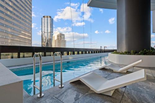 a swimming pool on the roof of a building at CASSA QW - Queens Wharf Modern Apartments Managed by The Cassa in Brisbane
