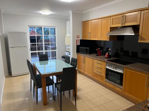 a kitchen with a table and chairs and a refrigerator at Maribel's Place in Funchal