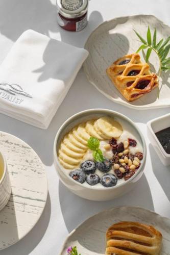 a table with a bowl of fruit and a bowl of bread at FU VALLEY Hotel in Liyang