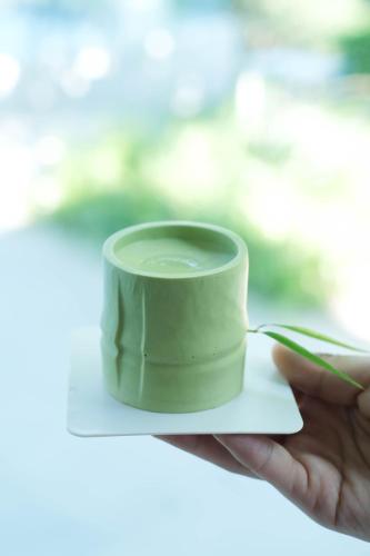 a hand holding a green cup on a piece of paper at FU VALLEY Hotel in Liyang
