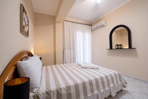 a bedroom with a bed with a striped blanket at Seaside Astros Getaway - La Maison Etoile in Paralion astros