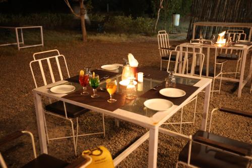 a table with plates and wine glasses on it at Jawai Bera Leopard Camp in Bera