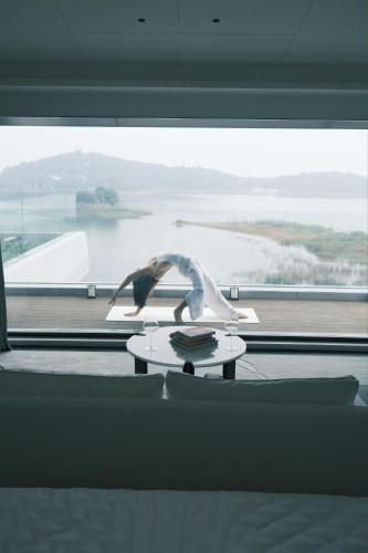 a table in front of a window with a view of a lake at FU VALLEY Hotel in Liyang
