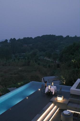 a person sitting at a table on the roof of a house at FU VALLEY Hotel in Liyang