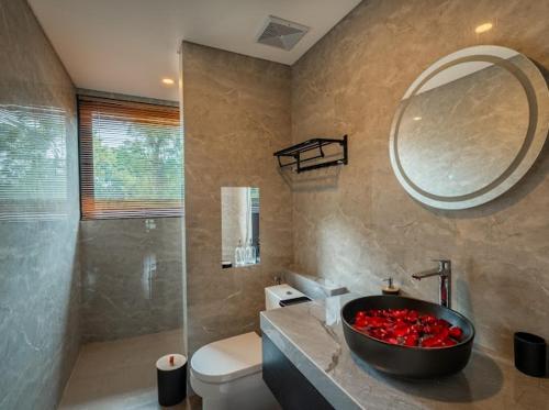 une salle de bain avec un lavabo et un miroir et des toilettes dans l'établissement Villa Sanur river view, à anur