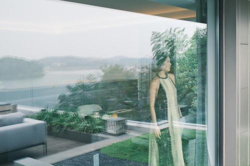a painting of a woman in a dress on a window at FU VALLEY Hotel in Liyang