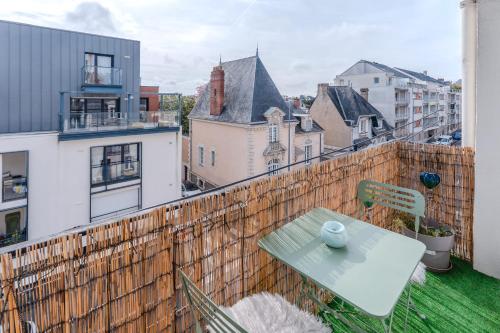 un balcon avec une table et une vue sur une ville dans l'établissement Le Nantais - Wifi - Parking, à Nantes