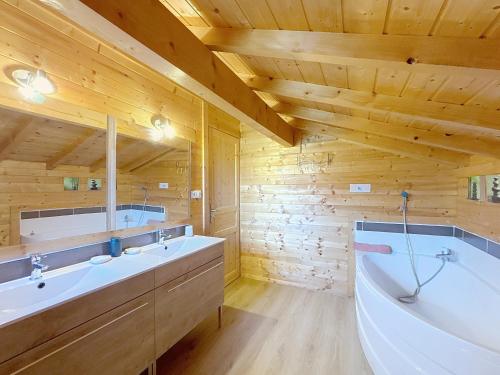 a bathroom with two sinks and a bath tub at Chalet du Géhan in Cornimont