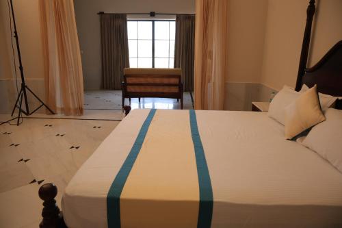 a bedroom with a bed with a blue stripe on it at Jawai Bera Leopard Camp in Bera